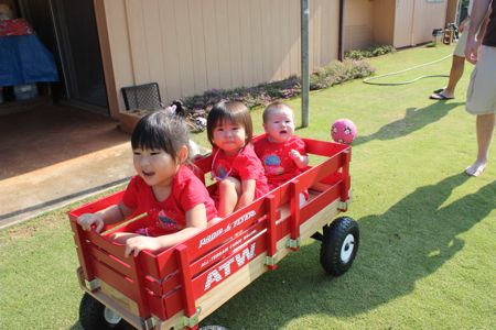 Three cuties all lined up in the Radio Flyer