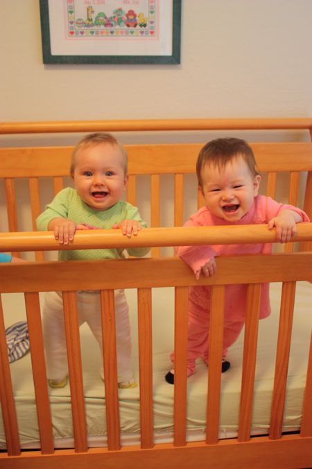 Maile and Hannah standing in a crib...