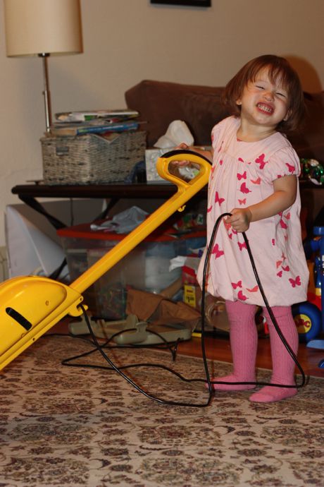 The smile is forced, but at least Maile Girl is cleaning up the house!