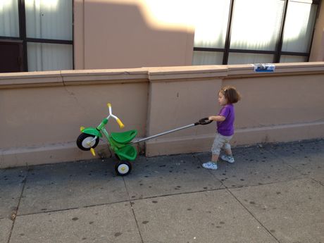 Maile's preferred way of riding her tricycle