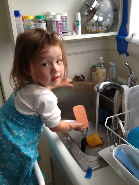 See Daddy, this is how you wash the dishes. She run the water, put some soap on the sponge and then you make sure you scrub all the dirty food off of the dish!
