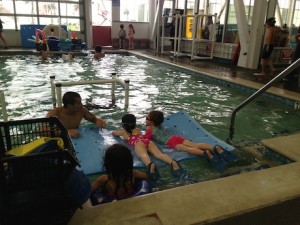 They use lots of floaties and toys to get the kids comfortable in the water - but they also teach them tricks like making a 'balloon face' so they don't swallow water when they put their face in.