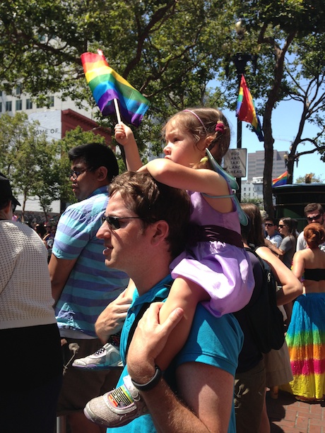 Maile and Daddy taking in the parade and waving our rainbow flag...