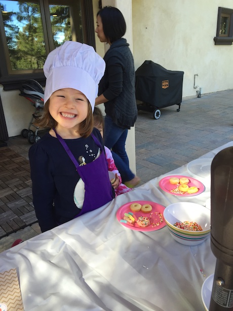 A very smiley donut decorating chef...