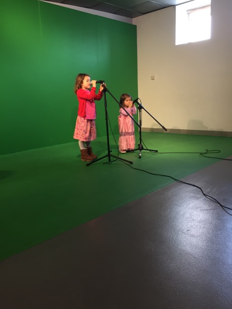 Maile and Lauren on the mics against the green screen