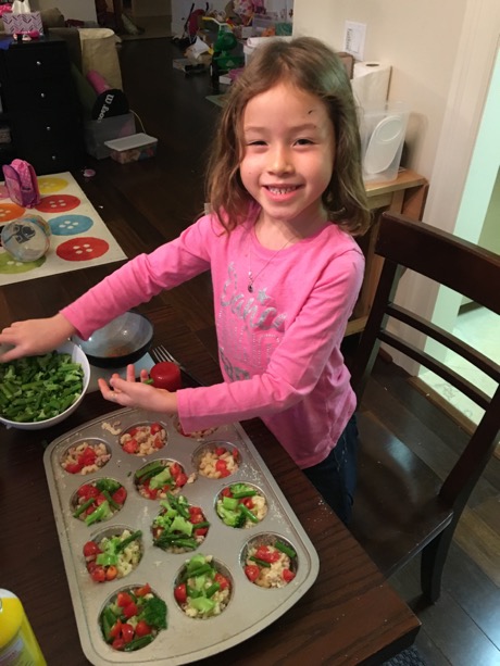 ... then Maile filled the cupcake tray with some macaroni, some cheese, some veggies and some bread crumbs.