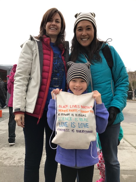 Maile and her homemade protest backpack with Mommy and Temple